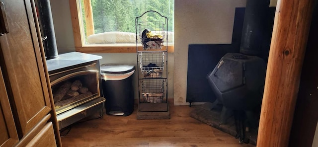 details featuring a wood stove and wood finished floors