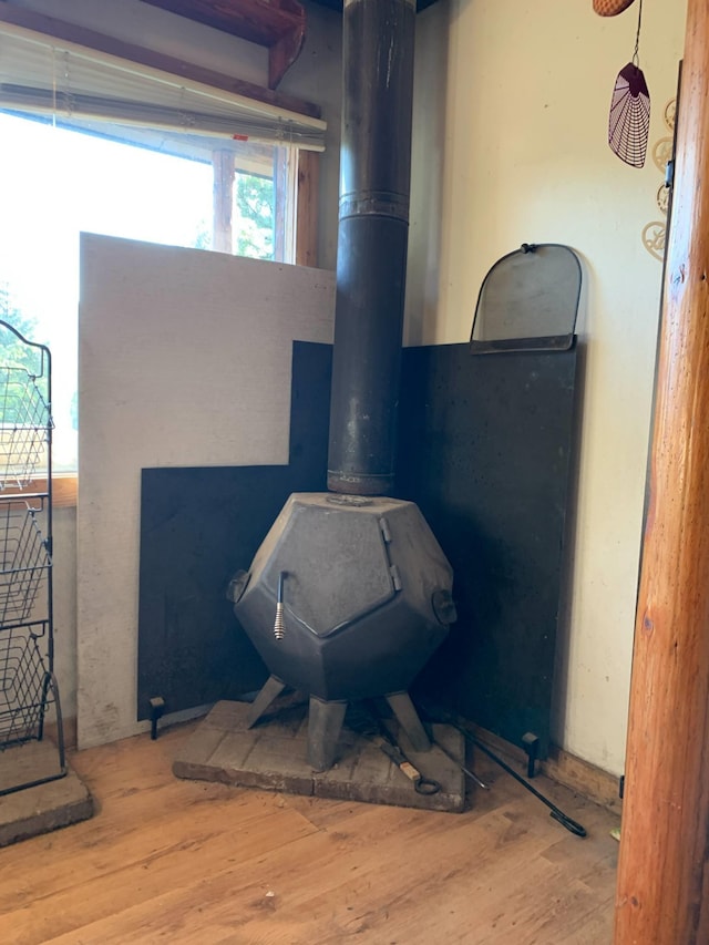 interior details with a wood stove and wood finished floors