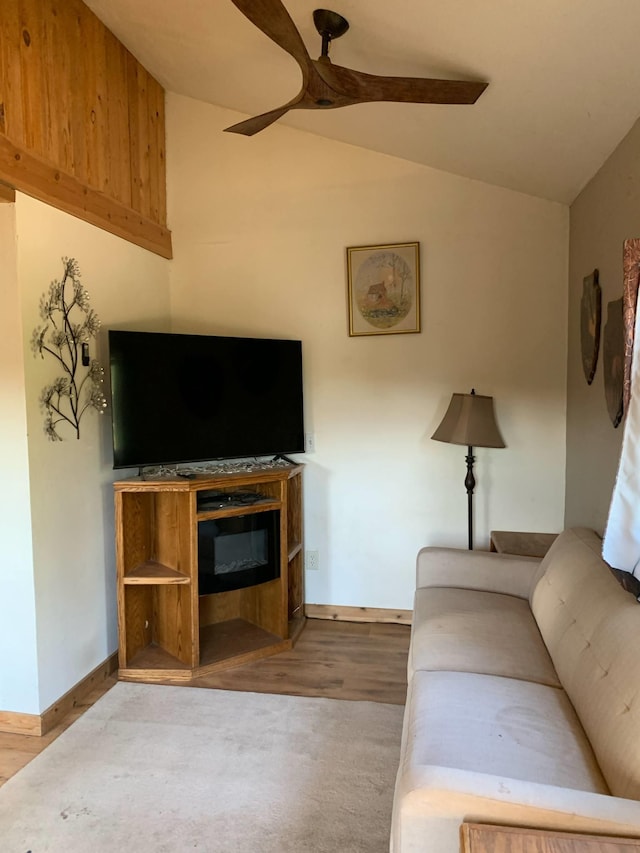 living area with baseboards, a ceiling fan, lofted ceiling, and wood finished floors