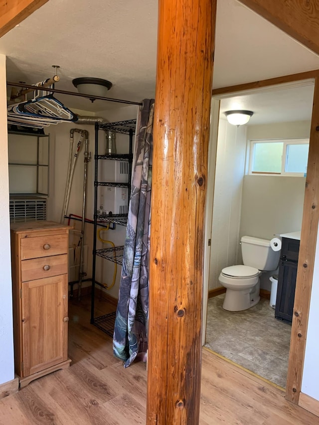 bathroom featuring wood finished floors and toilet