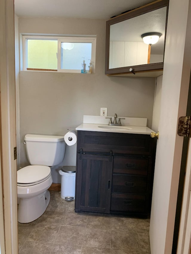 half bath with vanity, tile patterned floors, and toilet