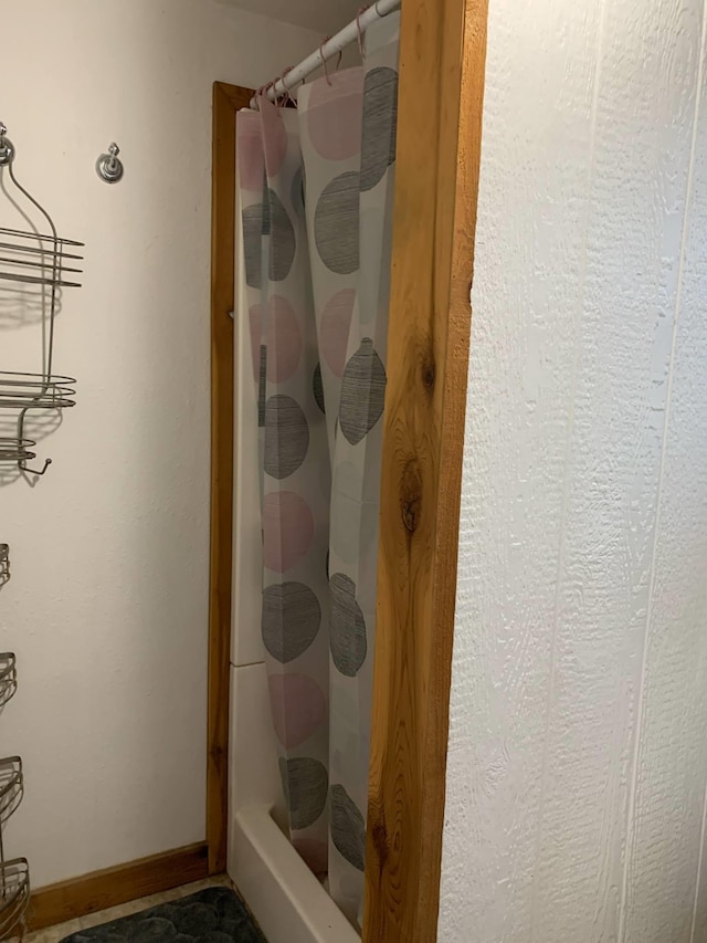 full bathroom with baseboards and a stall shower