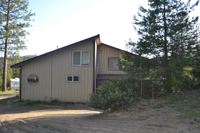 view of side of property featuring board and batten siding and driveway