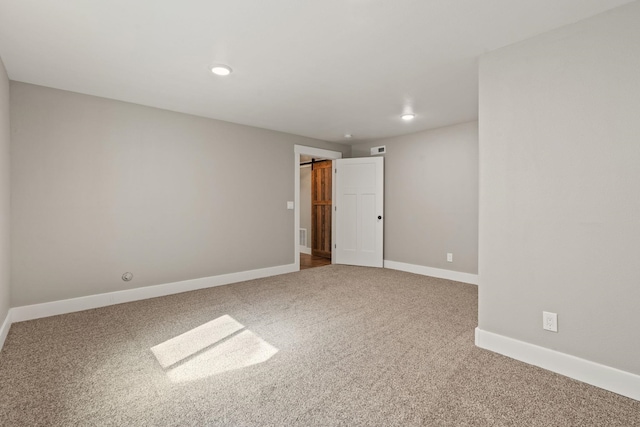 carpeted empty room featuring baseboards and recessed lighting