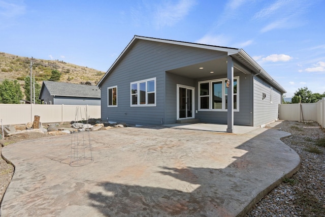 back of property with a fenced backyard and a patio area