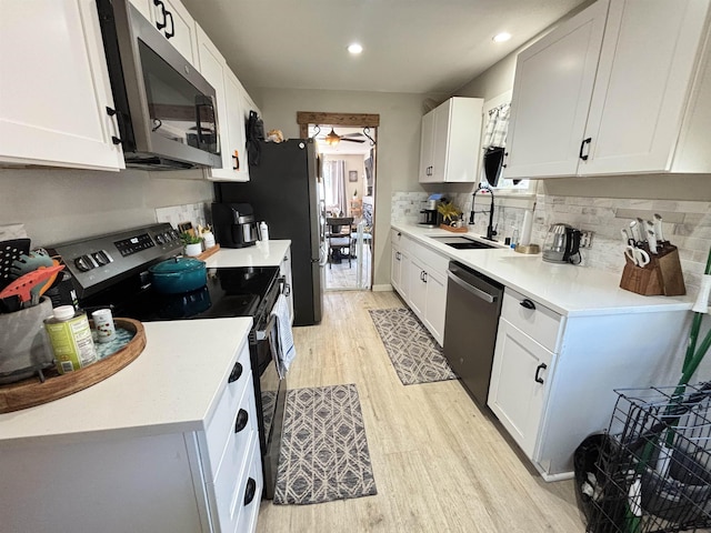 3204 W Queen Pl, Spokane, WA 99205 - kitchen featuring a ceiling fan, a sink, stainless steel appliances, tasteful backsplash, and light wood-type flooring