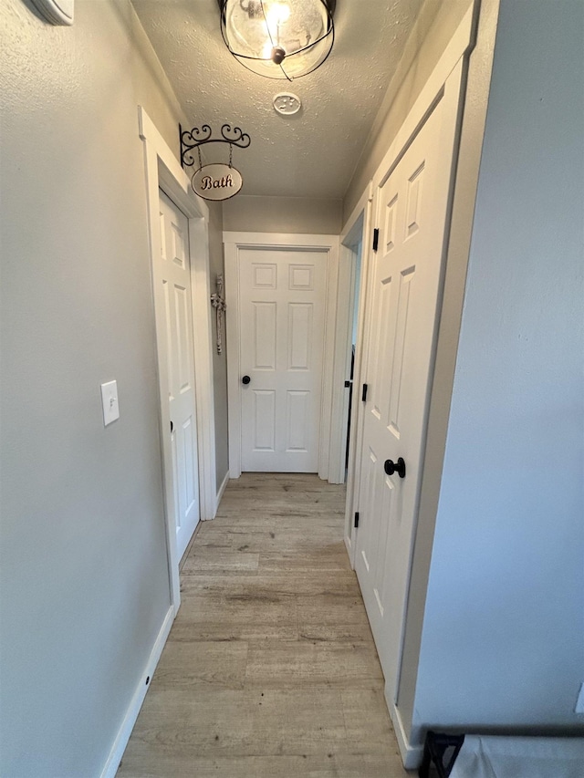 3204 W Queen Pl, Spokane, WA 99205 - corridor featuring a textured ceiling, baseboards, and light wood-type flooring