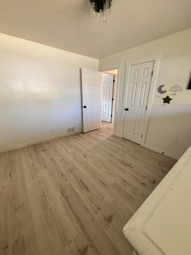 3204 W Queen Pl, Spokane, WA 99205 - unfurnished bedroom featuring a chandelier, baseboards, light wood-type flooring, and visible vents