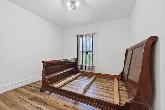 bedroom with baseboards and wood finished floors