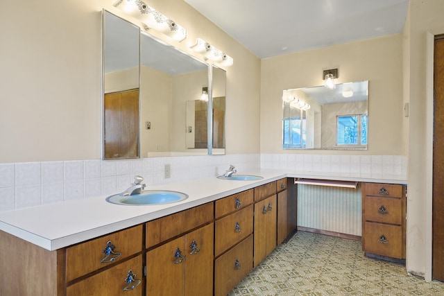 bathroom featuring a sink, backsplash, and double vanity