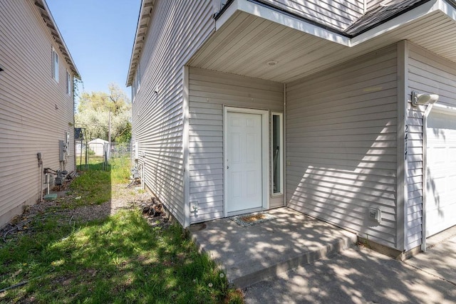 doorway to property with a garage and fence
