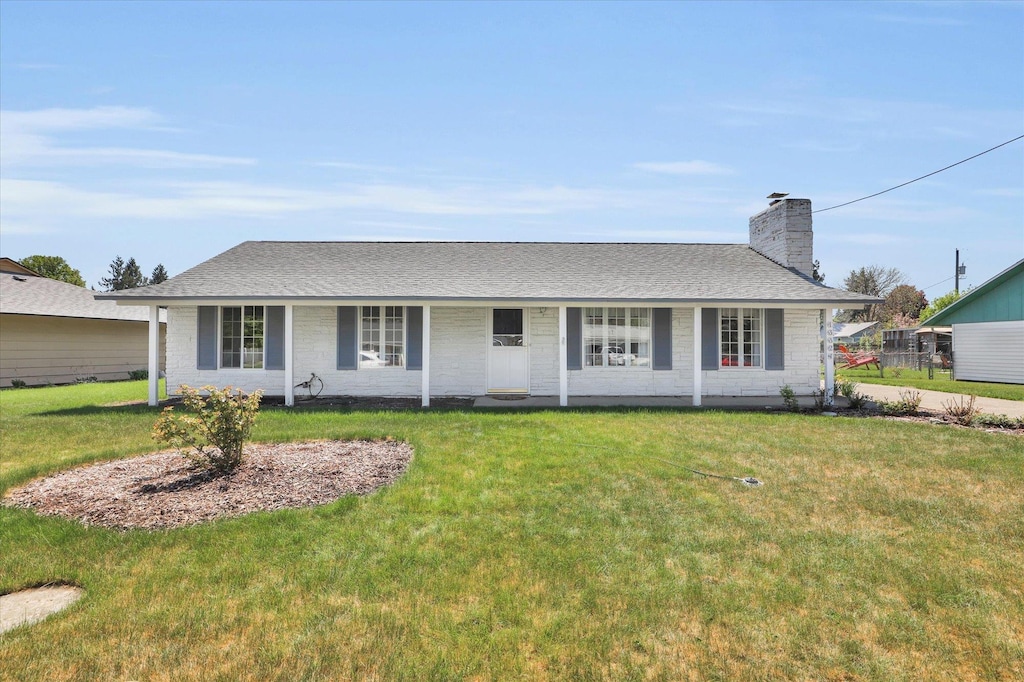 ranch-style home featuring a front lawn, a porch, roof with shingles, and a chimney