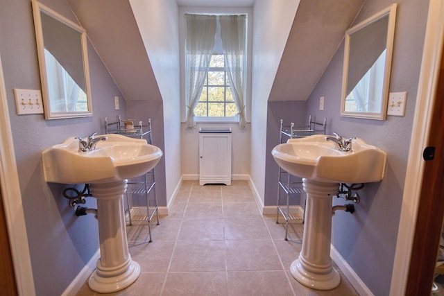 bathroom with vaulted ceiling, tile patterned flooring, and baseboards