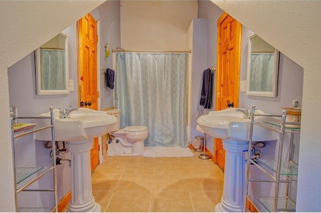 bathroom featuring tile patterned floors, toilet, and a shower with curtain