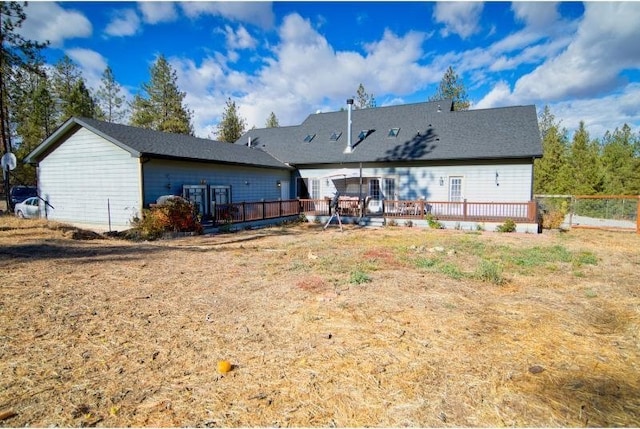 back of property with a deck and fence