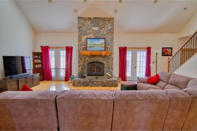 living area with lofted ceiling, stairs, and french doors