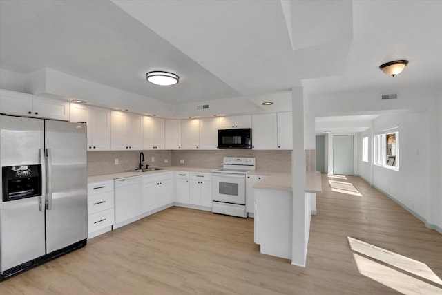 1801 W Sharp Ave, Spokane, WA 99201 - kitchen with white appliances, light countertops, light wood-style flooring, and white cabinetry