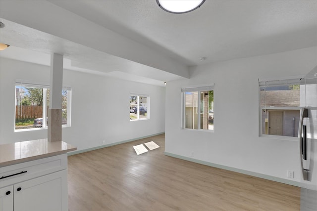 1801 W Sharp Ave, Spokane, WA 99201 - unfurnished living room with baseboards and light wood finished floors