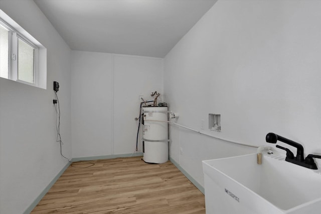 1801 W Sharp Ave, Spokane, WA 99201 - washroom with secured water heater, light wood-type flooring, and washer hookup
