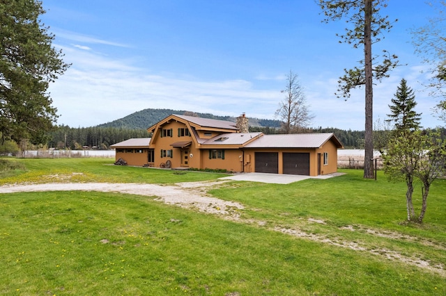 3247 Jumpoff Way, Valley, WA 99181 - view of front facade featuring a chimney, a mountain view, dirt driveway, a garage, and a front yard