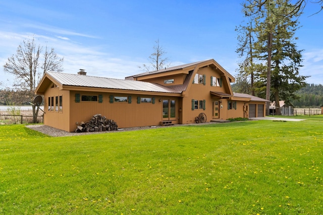 3247 Jumpoff Way, Valley, WA 99181 - back of property featuring an attached garage, a chimney, fence, metal roof, and a yard