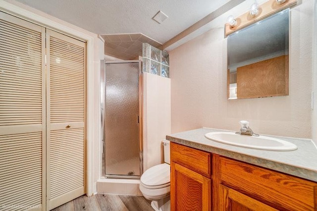 4023 W Hoffman Ave, Spokane, WA 99205 - bathroom featuring toilet, wood finished floors, a stall shower, a closet, and vanity