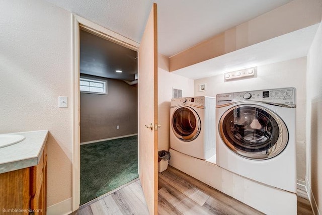 4023 W Hoffman Ave, Spokane, WA 99205 - laundry area featuring a sink, separate washer and dryer, and wood finished floors