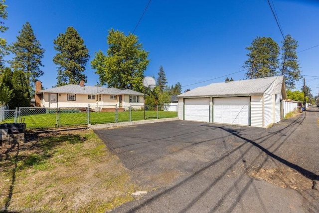 4023 W Hoffman Ave, Spokane, WA 99205 - view of front of property with fence, a detached garage, a front lawn, and an outdoor structure