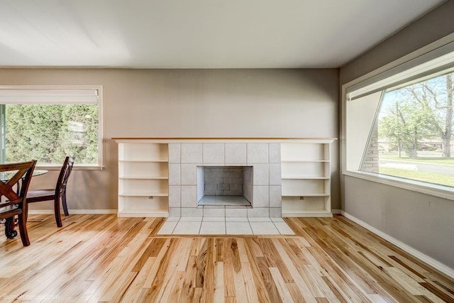 4023 W Hoffman Ave, Spokane, WA 99205 - unfurnished living room featuring a tile fireplace, baseboards, and wood finished floors