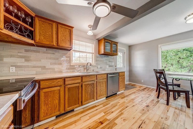 4023 W Hoffman Ave, Spokane, WA 99205 - kitchen featuring a sink, stainless steel appliances, brown cabinets, light wood-style flooring, and light countertops
