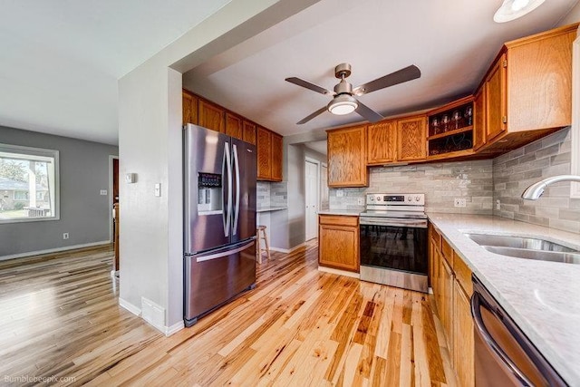 4023 W Hoffman Ave, Spokane, WA 99205 - kitchen with a ceiling fan, a sink, light wood-style floors, stainless steel appliances, and tasteful backsplash