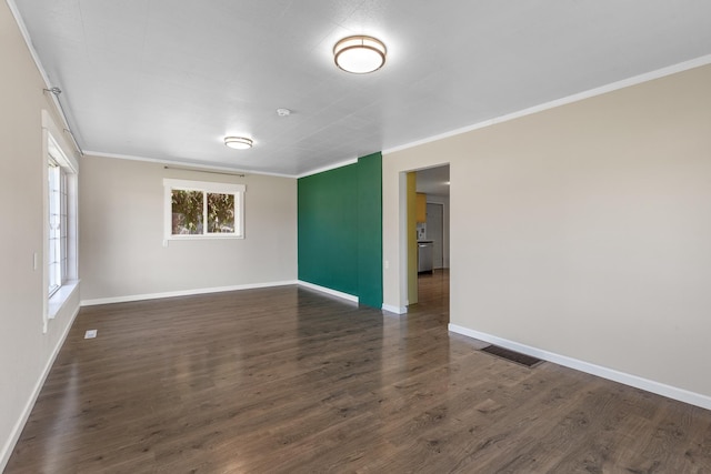 empty room featuring crown molding, baseboards, visible vents, and dark wood finished floors