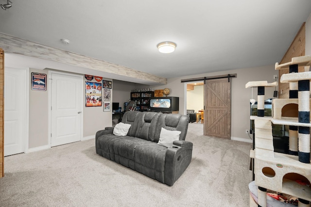 carpeted living room with a barn door and baseboards