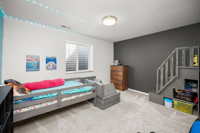 carpeted bedroom featuring visible vents