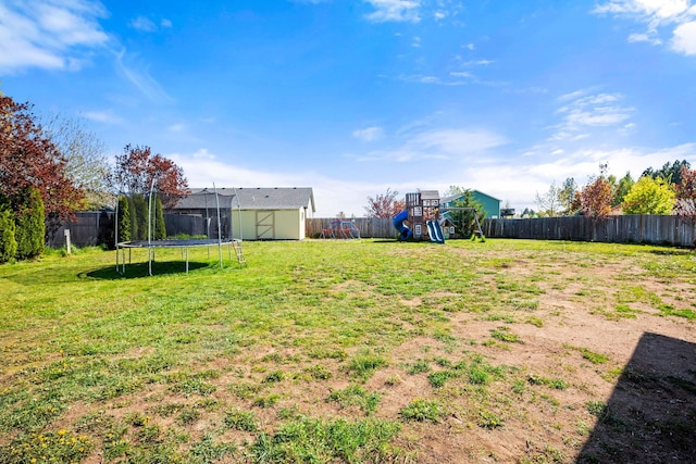 view of yard with an outdoor structure, a trampoline, a playground, a fenced backyard, and a storage unit