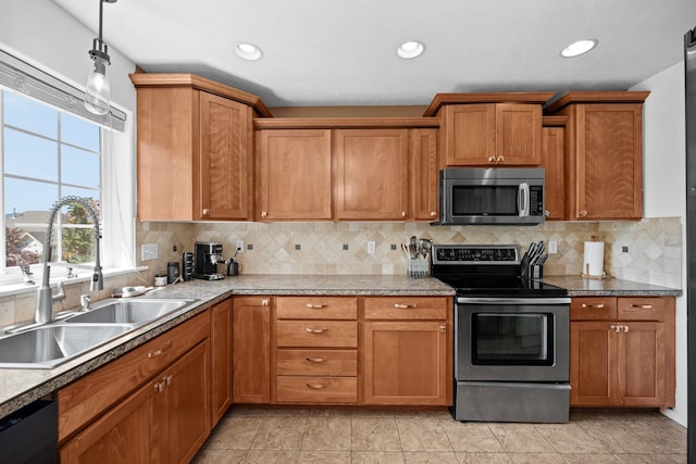 kitchen featuring brown cabinets, decorative backsplash, appliances with stainless steel finishes, and a sink