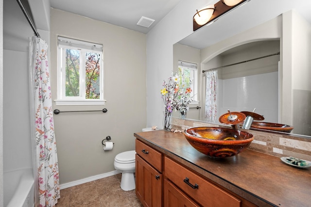 full bath featuring vanity, toilet, baseboards, and a healthy amount of sunlight
