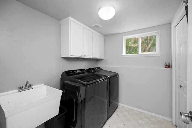 clothes washing area featuring washer and clothes dryer, a sink, cabinet space, visible vents, and baseboards