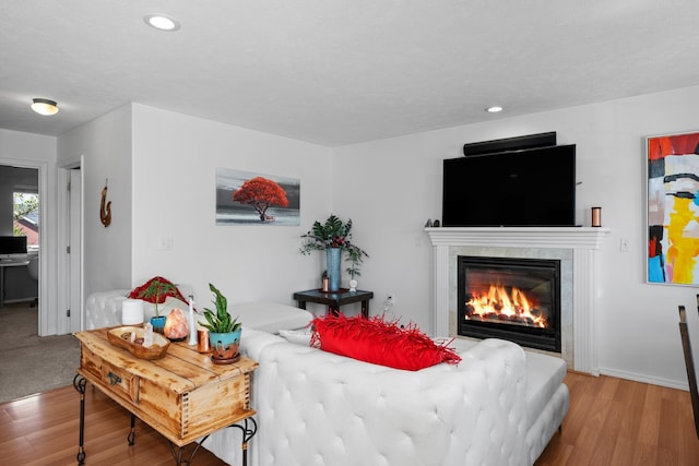 living area with baseboards, a fireplace, recessed lighting, and wood finished floors