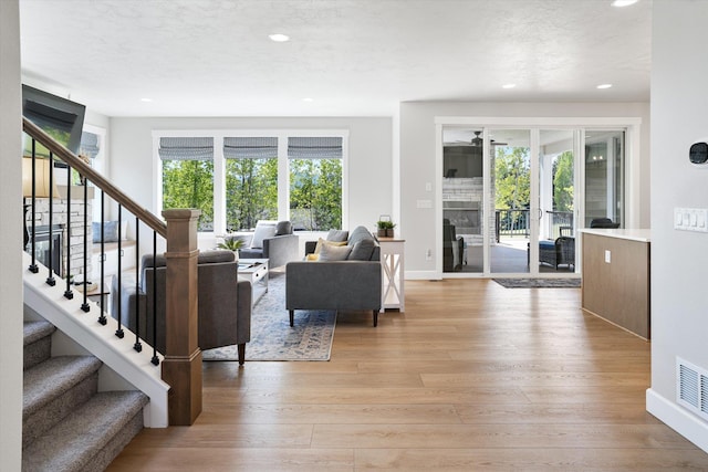 living room with baseboards, stairway, recessed lighting, and light wood-style floors