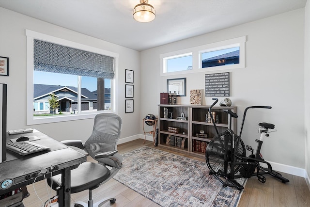 home office with baseboards and wood finished floors