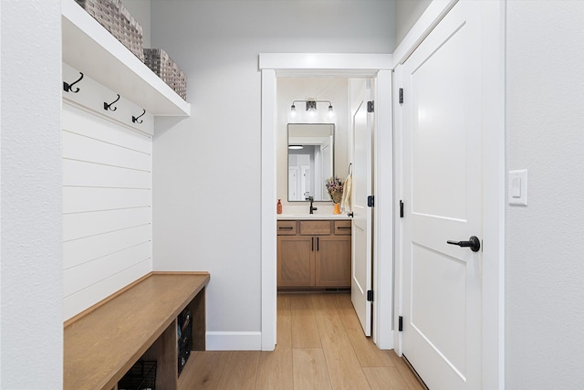 mudroom with light wood-style floors and baseboards
