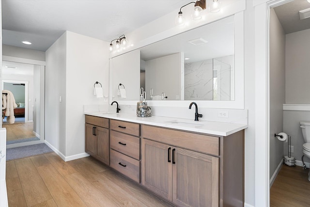 bathroom with toilet, a sink, and wood finished floors