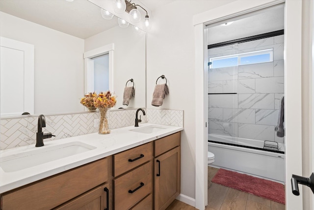 full bathroom with a sink, toilet, and decorative backsplash