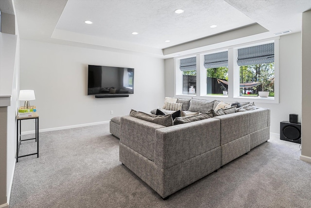carpeted living area featuring baseboards, a raised ceiling, recessed lighting, and visible vents