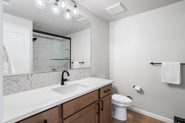 bathroom with baseboards, toilet, vanity, decorative backsplash, and a marble finish shower
