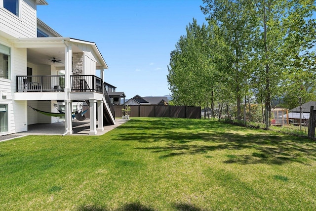 view of yard featuring a ceiling fan, a patio area, stairway, and fence