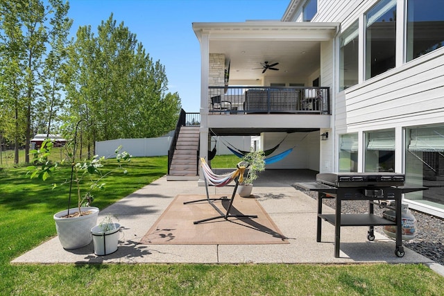 view of patio with fence, ceiling fan, and stairs