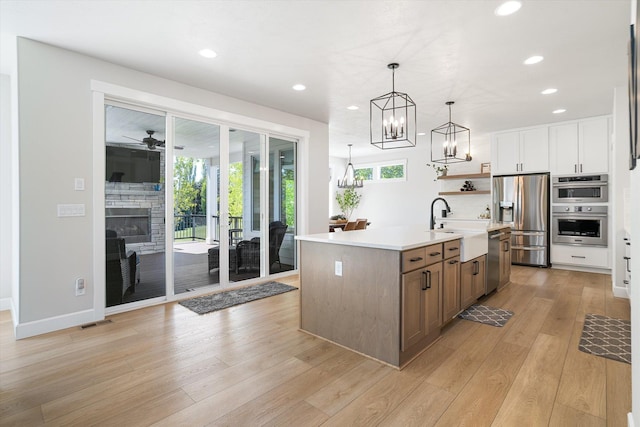 kitchen with a sink, stainless steel appliances, open shelves, recessed lighting, and light countertops