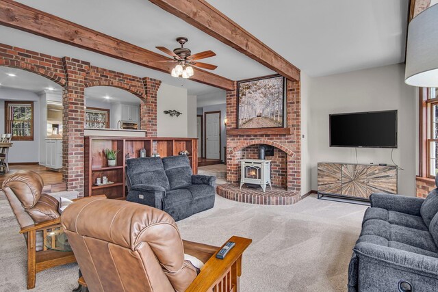 21724 N Perry Rd, Colbert, WA 99005 - living room featuring a ceiling fan, carpet flooring, a healthy amount of sunlight, arched walkways, and a wood stove